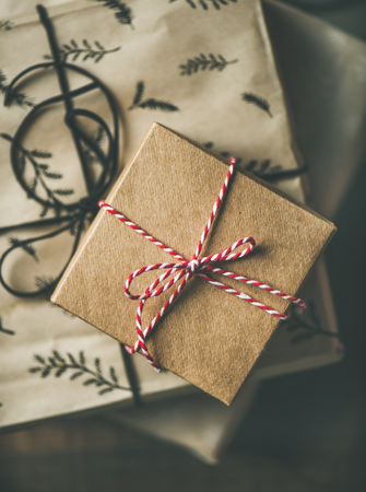 Preparing for Christmas or New Year holiday. Flat-lay of gift boxes, rope, scissors over rustic...