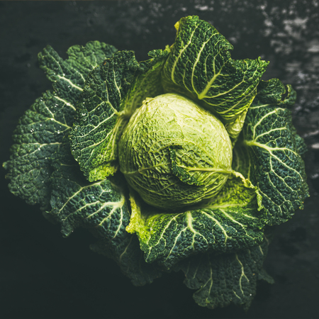 Raw fresh green cabbage over dark background, top view, selective focus, square cropの写真素材