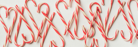 Christmas holiday red candy cane pattern, texture and background on white background, flat-lay, copy space, wide compositionの写真素材