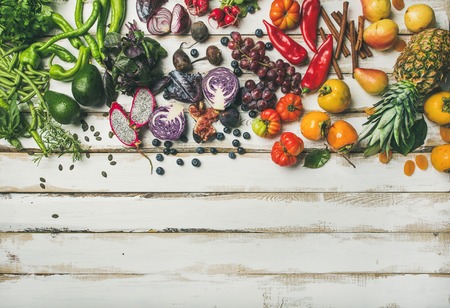 Helathy raw vegan food cooking background. Flat-lay of fresh fruit, vegetables, greens and superfoods over white wooden table, top view, copy space. Clean eating, alkaline diet, vegetarian conceptの写真素材