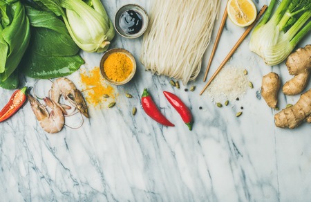 Asian cuisine ingredients over marble background, top view, copy space. Flat-lay of vegetables, spices, shrimp, sauces for cooking vietnamese, thai or chinese food. Clean eating, vegetarian conceptの写真素材