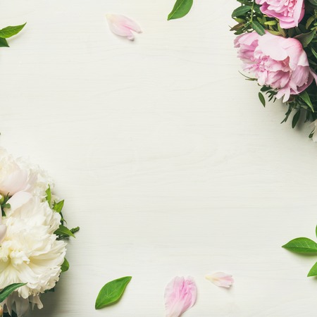 Spring flowers layout. Flat-lay of tender pale pink and white peonies over white background, top view, copy space, square crop. Womens, Valentines or lovers day greeting card or wedding invitation