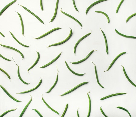 Food pattern, texture and background. Flat-lay of fresh green beans over white wooden background, top view. Healthy cooking, clean eating, vegan, vegetarian, dieting conceptの写真素材
