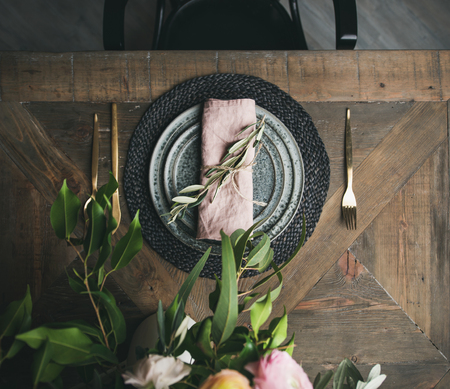 Flat-lay of Spring Easter holiday Table setting. Tender blossom flowers, plates and cutlery over vintage wooden table, top viewの写真素材