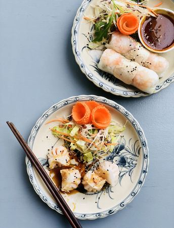 Asian style dinner. Flat-lay of steamed dumplings Dim sum and summer rice paper rolls with shrimp...