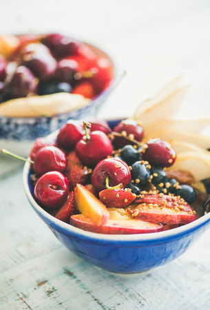 Healthy smoothie bowl with fresh fruit and berries, bee pollen and honey on blue table background for breakfast. Clean eating, vegan, vegetarian, weight loss, alcaline diet, fitness nutrition conceptの写真素材