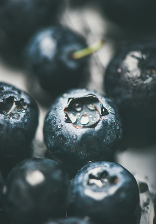 Fresh blueberry texture, wallpaper and background. Wet dark forest blueberries on dark background, selective focus, vertical composition, close-up. Summer food or local market produce conceptの写真素材