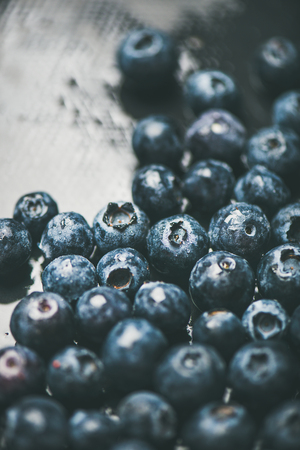 Fresh blueberry texture, wallpaper and background. Wet dark forest blueberries on dark background, selective focus. Summer food or local market produce conceptの写真素材