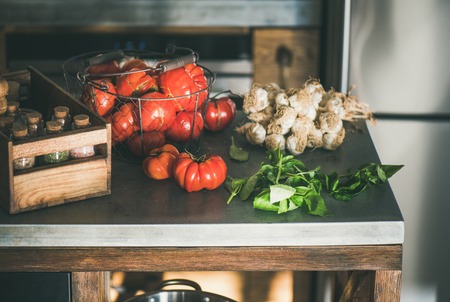 Modern kitchen concrete counter with ingredients for cooking tomato sauce