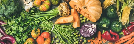 Healthy vegetarian seasonal Fall food cooking background. Flat-lay of Autumn vegetables and herb from local market over grey concrete background, top view, wide composition. Vegan, alkaline diet foodの写真素材