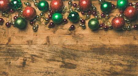 Christmas, New Year holiday background, texture, wallpaper. Flat-lay of colorful green, red, golden christmas tree decoration balls on wooden background, top view, copy space. New year greeting cardの写真素材