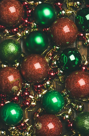 Christmas or New Year holiday background, texture, wallpaper. Flat-lay of colorful green, red and golden christmas tree decoration balls, top view, vertical composition. New year greeting card conceptの写真素材