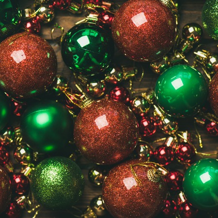 Christmas or New Year holiday background, texture, wallpaper. Flat-lay of colorful green, red and golden christmas tree decoration balls, top view, square crop. New year greeting card conceptの写真素材