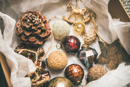 Christmas or New Year preparations. Flat-lay of various vintage Christmas tree decoration toys in box, top view. Festive holiday moodの写真素材