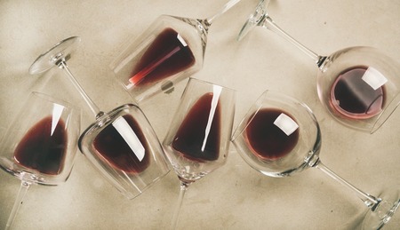 Flat-lay of red wine in glasses over grey concreteの写真素材