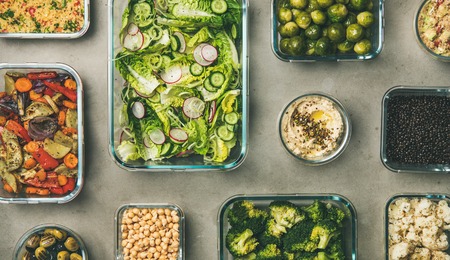 Healthy vegan dishes in containers. Flat-lay of fresh and cooked vegetable salad, legumes, beans,...