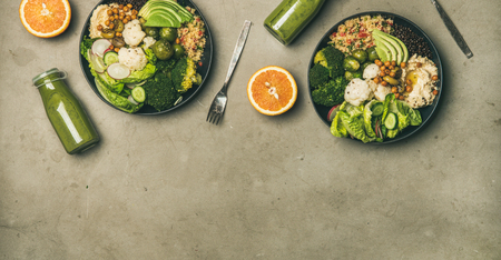 Healthy dinner, lunch setting. Flat-lay of vegan superbowls or Buddha bowls with hummus, vegetable, salad, beans, couscous, avocado and green smoothies in bootles, top view, copy spaceの写真素材