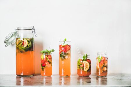 Homemade strawberry and basil lemonade or ice tea in glass tumblers with eco-friendly plastic-free...