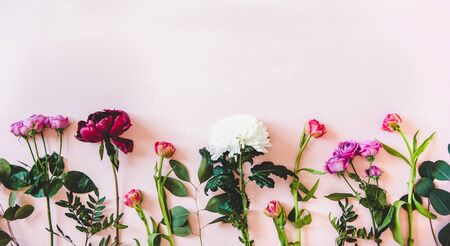 Summer flowers flat-lay. Purple peonies, pink roses and tulips, white chrysanthemums and green branches over pastel pink background, top view, copy space. Flower texture, wallpaper, backgroundの写真素材