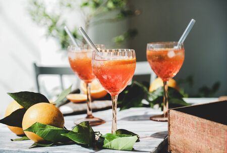 Spritz aperitif alcohol cocktail in glasses with fresh oranges and ice on grey marble board, selective focus, close-up. Summer refreshing drink conceptの写真素材