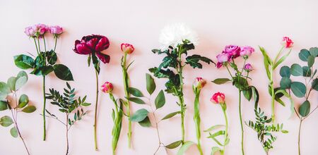 Various summer flowers flat-lay. Purple peonies, pink roses and tulips, white chrysanthemums and green branches over pastel pink background, top view, copy space. Flower texture, wallpaper, backgroundの写真素材