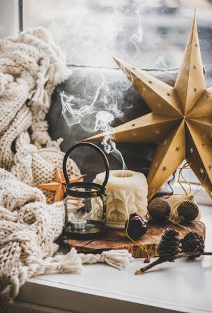 Christmas festive holiday mood composition with candles, smoke and decorative toys on wooden boardの写真素材