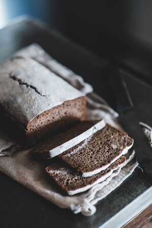 Healthy rye Swedish bread loaf cut in slices covered with flour with vintage knife on cotton towel...