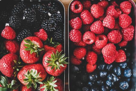Fresh seasonal strawberries, raspberries, blueberries and blackberries in lunchboxesの写真素材