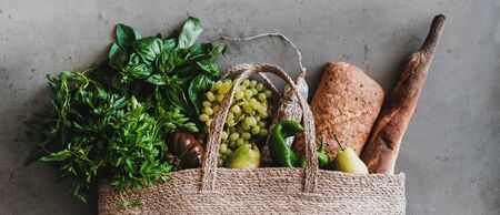 Flat-lay of healthy grocery shopping eco-friendly bag with fresh vegetables, fruit, greens, herbs,...
