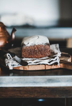 Healthy rye Swedish bread loaf cut in slices covered with flour with vintage knife on wooden boardの写真素材