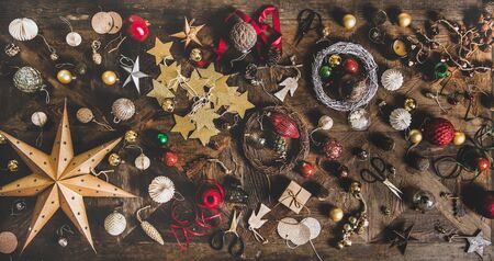 Christmas, New Year holiday layout background, texture, wallpaper. Flat-lay of decorative objects, fur tree toys, garlands, ropes, wreaths over wooden background, top view. Winter holidays preparationの写真素材