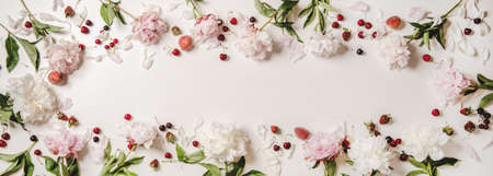 Summer fruit and flowers layout. Flat-lay of white and pink peony flowers, cherries, strawberries and peaches over plain white background, top view, copy spaceの写真素材