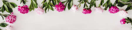 Summer flowers layout. Flat-lay of pink and purple peony flowers arrangement over plain white background, top view, copy space. Florist shop website banner or wallpaperの写真素材