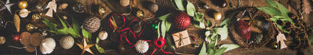 Christmas, New Year holiday background, texture, wallpaper. Flat-lay of decorative objects, fur tree toys, garland, ropes, candles, glass balls, wreaths over rustic wooden background, wide compositionの写真素材