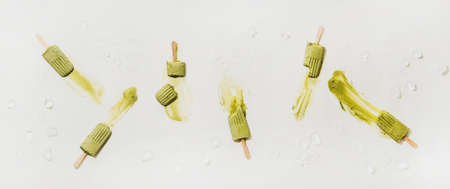 Green matcha coconut vegan ice cream  . Flat-lay of melting matcha  over plain white table background with ice, top view. Summer healthy dessert, clean eating, dairy free food conceptの写真素材