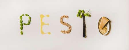 Ingredients for cooking Italian Pesto sauce. Flat-lay of fresh basil leaves, olive oil, pine nuts, garlic, Parmesan cheese forming word pesto over plain white background, top view. Ligurian cuisineの写真素材