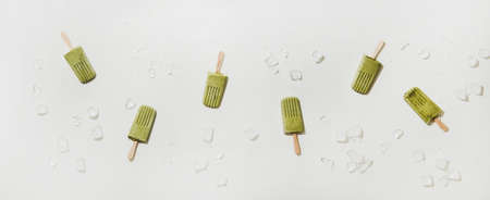Green matcha coconut vegan ice cream  . Flat-lay of matcha  over white table background with ice cubes, top view. Summer healthy dessert, clean eating, dairy free food conceptの写真素材