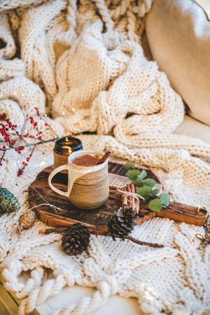 Turkish traditional wintertime hot drink Salep. Mug of sweet warming Salep drink with ground cinnamon on tray over knitted blanket in bed. Turkish seasonal cuisine, Christmas and New Year moodの写真素材