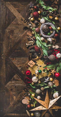 Christmas, New Year holiday layout background, texture, wallpaper. Flat-lay of decorative objects, fur tree toys, garlands, ropes, candles, glass balls, wreaths over wooden background, copy spaceの写真素材