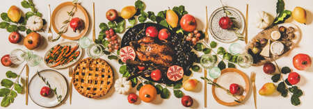 Autumn Thanksgiving, Friendsgiving, family gathering dinner table setting. Flat-lay of Fall decorated table with roasted duck in seasonal fruits, vegetables, cheese board, apple pie and wineglassesの写真素材