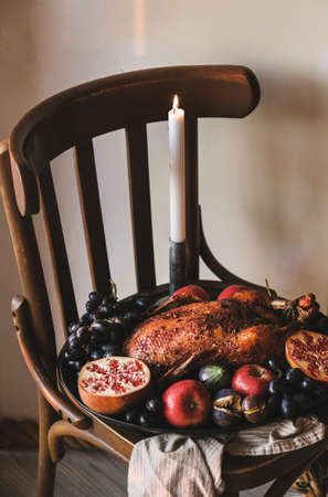 Whole oven roasted duck in ripe seasonal fruits for Thanksgiving holiday or Christmas eve party celebration on tray over wooden stool, top view. Traditional Autumn or Winter holiday comfort foodの写真素材