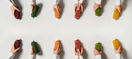 Hands holding fresh natural organic juices in bottles, copy spaceの写真素材