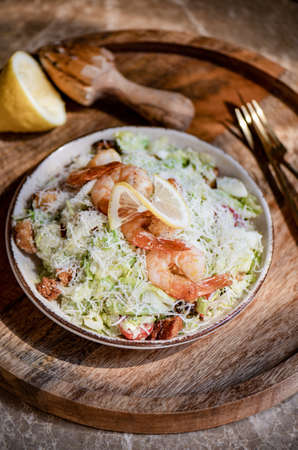 Healthy Shrimp Caesar salad bowl with parmesan cheese and lemonの写真素材
