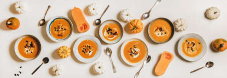 Flat-lay of pumpkin cream soup with sour cream, seeds, routonsの写真素材