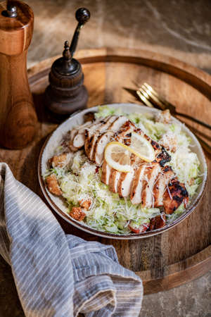 Classic roasted chicken Caesar salad bowl with croutons and parmesanの写真素材