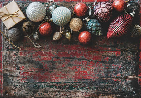 Christmas decoration toys and balls over red rustic wooden backgroundの写真素材