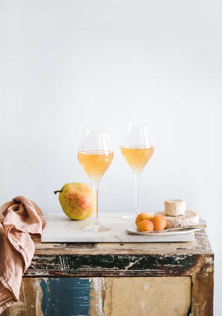 Orange Amber wine in glasses, fruits and cheese, copy spaceの写真素材