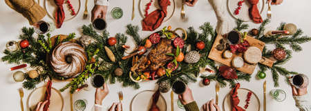 Flat-lay of Festive Christmas table setting and celebrating people handsの写真素材