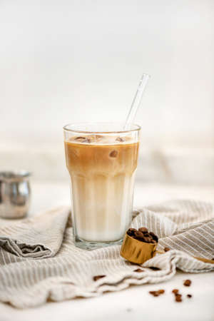 Iced latte coffee drink in tall glass over white backgroundの写真素材