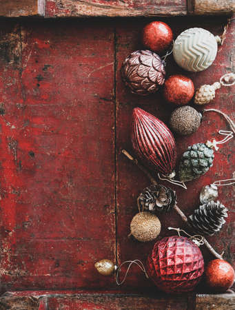 Christmas decoration toys and balls over dark red rustic wooden backgroundの写真素材